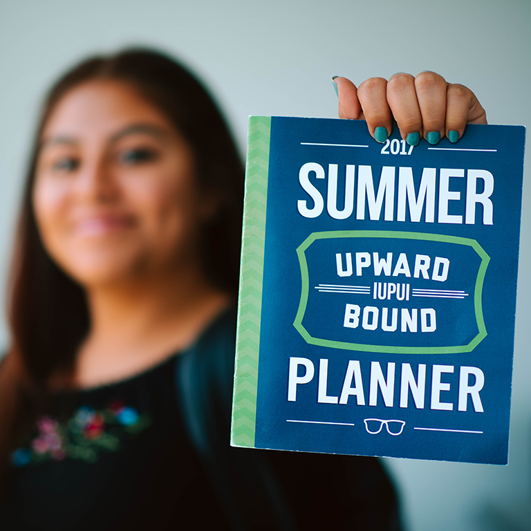 A student holding the summer planner.